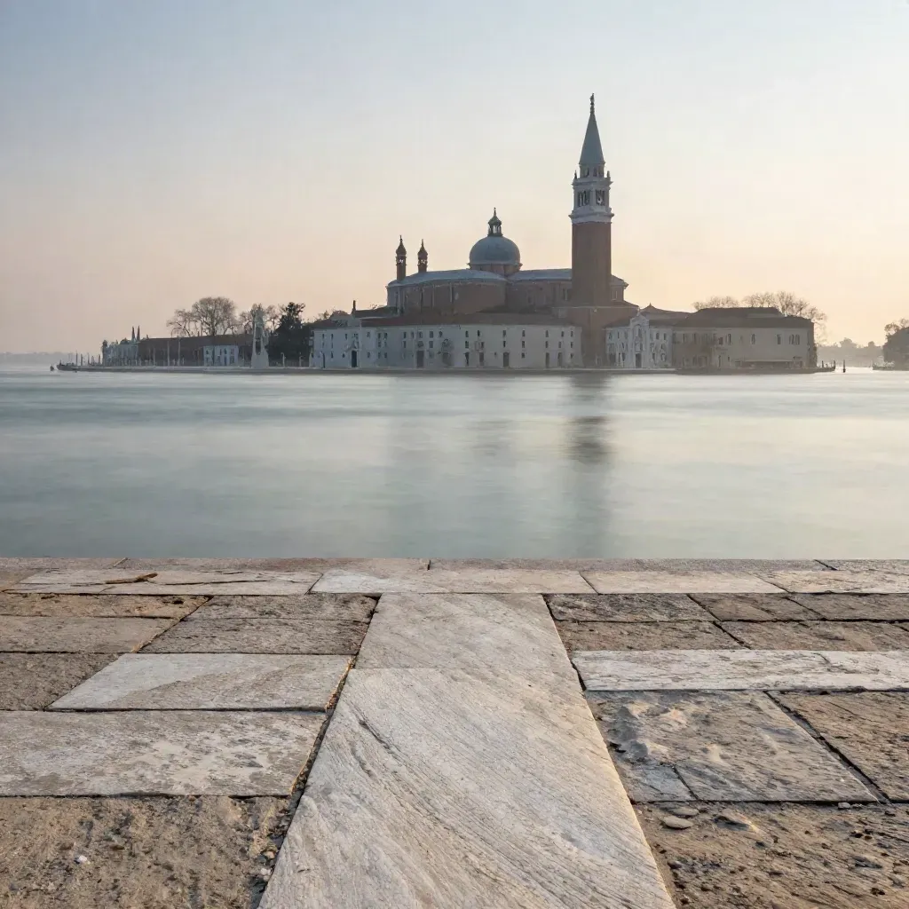 Laguna veneta al tramonto con San Giorgio Maggiore in alto e pietra chiara in primo piano.
